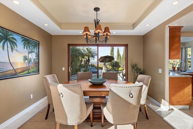 dining room featuring baseboards, a tray ceiling, a notable chandelier, and recessed lighting