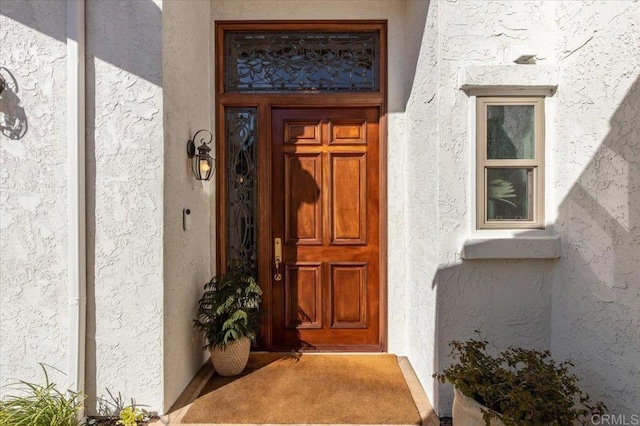 view of exterior entry with stucco siding