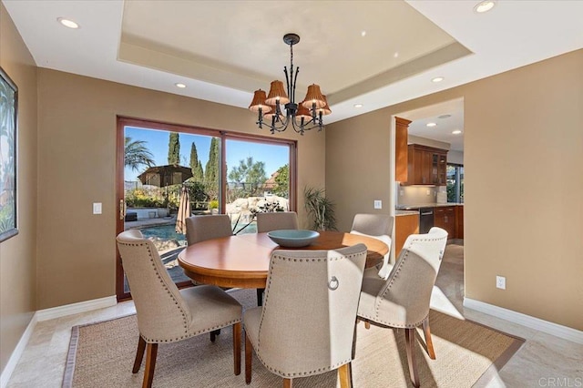 dining room featuring a notable chandelier, a tray ceiling, recessed lighting, and baseboards