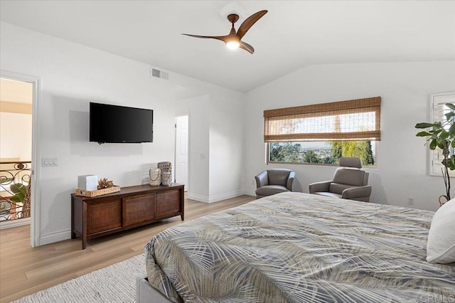 bedroom featuring lofted ceiling, wood finished floors, visible vents, and baseboards