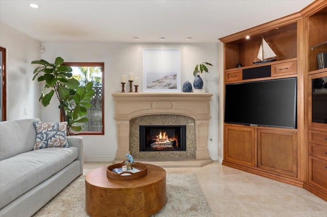 living room with recessed lighting, a fireplace, and baseboards