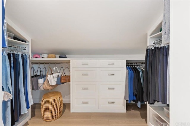 walk in closet with light wood-style floors