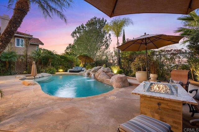 view of pool with a fire pit, a patio, and fence