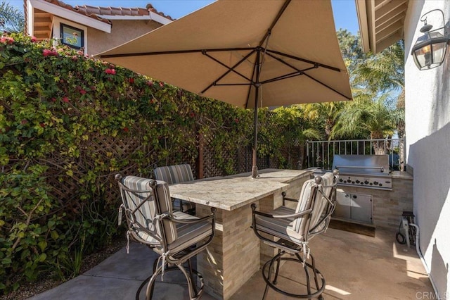 view of patio / terrace featuring an outdoor bar and area for grilling