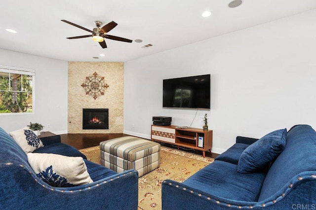 living area featuring a large fireplace, baseboards, visible vents, wood finished floors, and recessed lighting