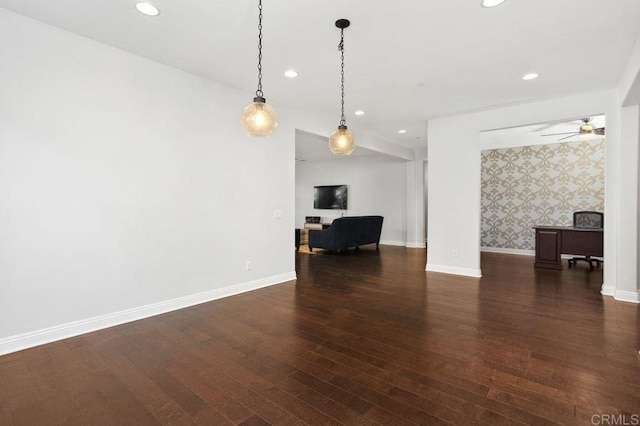 unfurnished living room featuring wallpapered walls, baseboards, wood finished floors, and recessed lighting