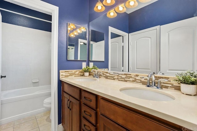 bathroom featuring tile patterned flooring, a sink, toilet, and decorative backsplash