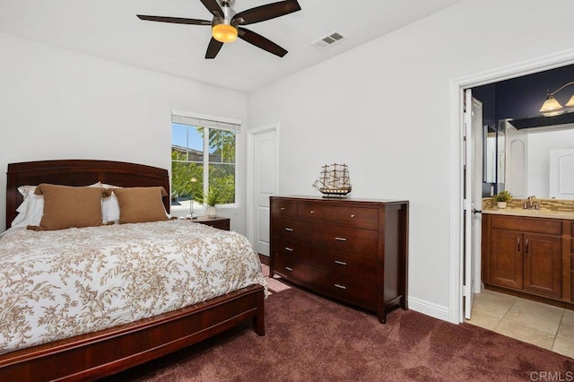 bedroom featuring connected bathroom, a sink, visible vents, baseboards, and carpet