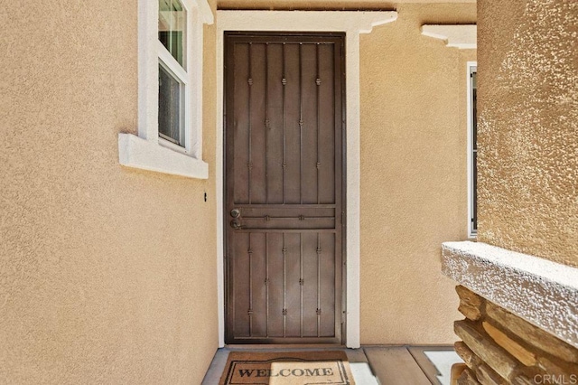 view of exterior entry featuring stucco siding