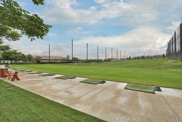 view of community featuring a lawn and fence