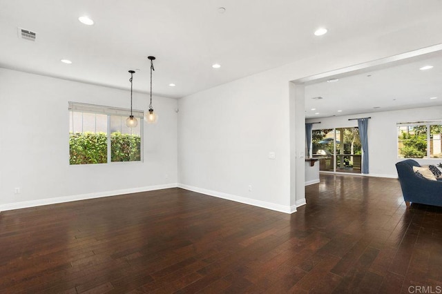 empty room featuring dark wood-type flooring, recessed lighting, visible vents, and baseboards