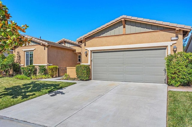 ranch-style home with a garage, concrete driveway, a front yard, and stucco siding