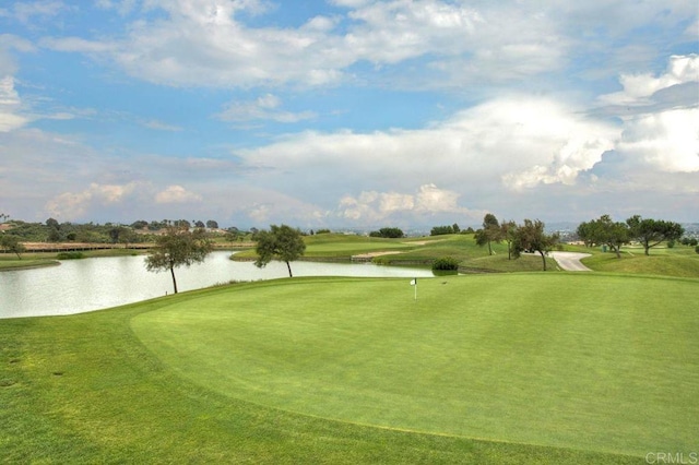 view of home's community featuring a water view, a lawn, and golf course view