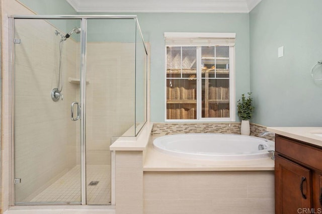 bathroom with ornamental molding, a stall shower, a garden tub, and vanity