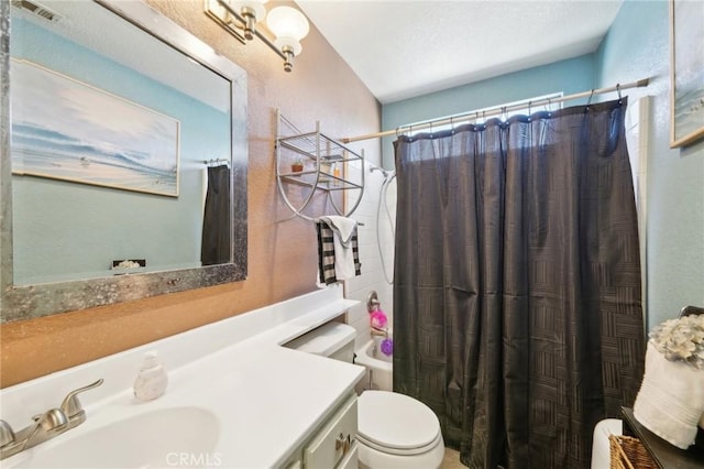 full bathroom with toilet, shower / tub combo, visible vents, and vanity