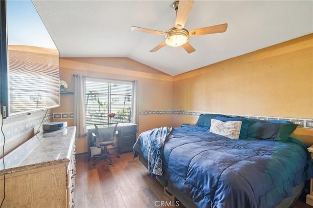 bedroom with vaulted ceiling, ceiling fan, and dark wood-style flooring