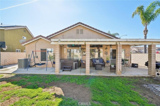 rear view of house featuring a patio, stucco siding, central air condition unit, a hot tub, and fence