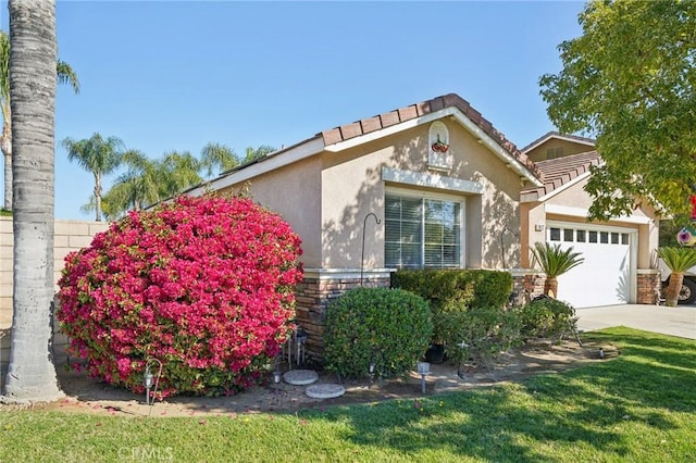 view of front facade featuring a front yard, driveway, an attached garage, and stucco siding