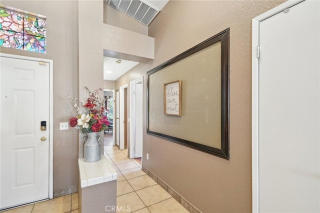 foyer featuring light tile patterned floors, visible vents, and baseboards