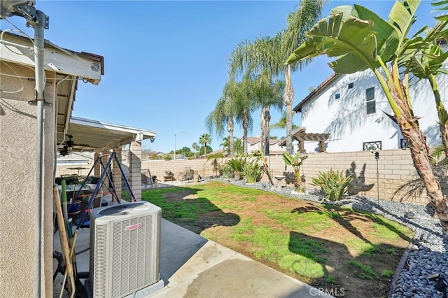 view of yard with a patio area, a fenced backyard, ceiling fan, and central air condition unit