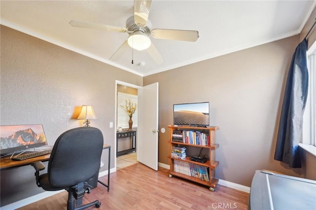 office area with baseboards, light wood-type flooring, and crown molding