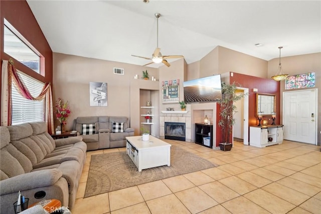 living room featuring light tile patterned floors, built in shelves, a fireplace, and visible vents