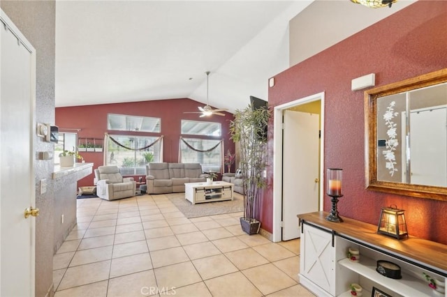 living room with lofted ceiling, light tile patterned floors, and a ceiling fan