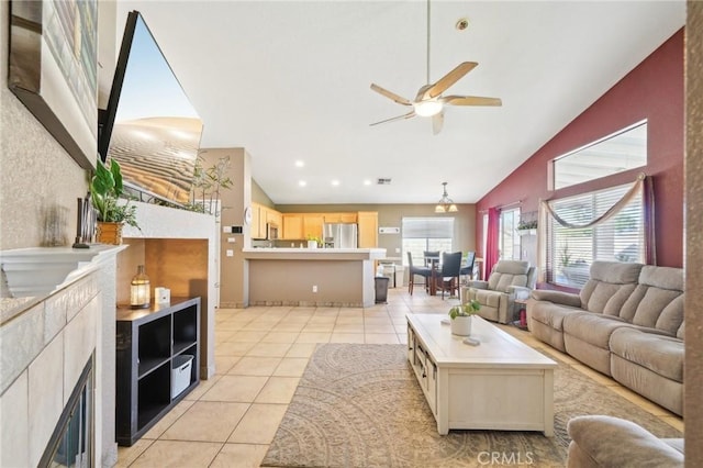 living room featuring a ceiling fan, visible vents, light tile patterned flooring, and high vaulted ceiling