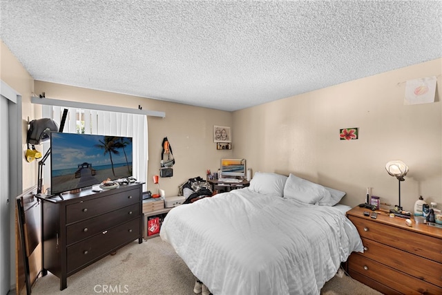 bedroom featuring light carpet and a textured ceiling