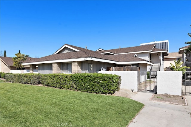 view of front of house with a fenced front yard, a front yard, and a gate