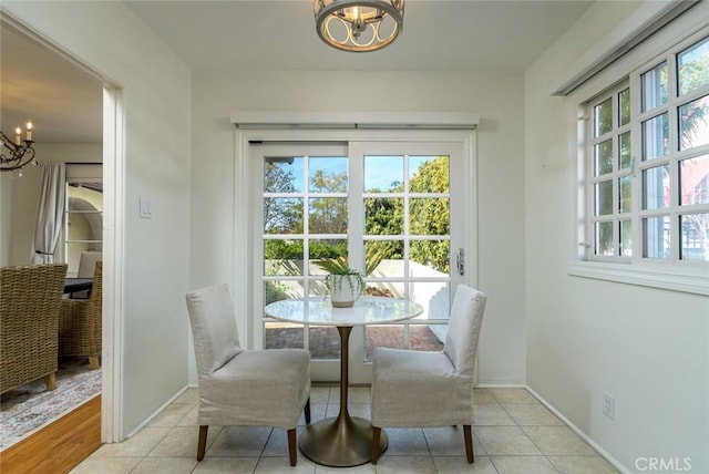 dining space with tile patterned flooring, baseboards, and an inviting chandelier