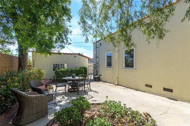 view of patio featuring outdoor dining space and fence