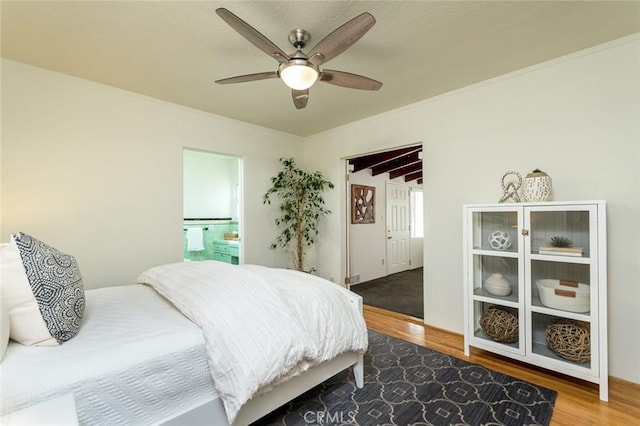 bedroom featuring ensuite bathroom, ceiling fan, ornamental molding, and wood finished floors