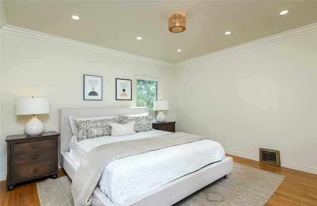 bedroom featuring recessed lighting, wood finished floors, visible vents, baseboards, and crown molding