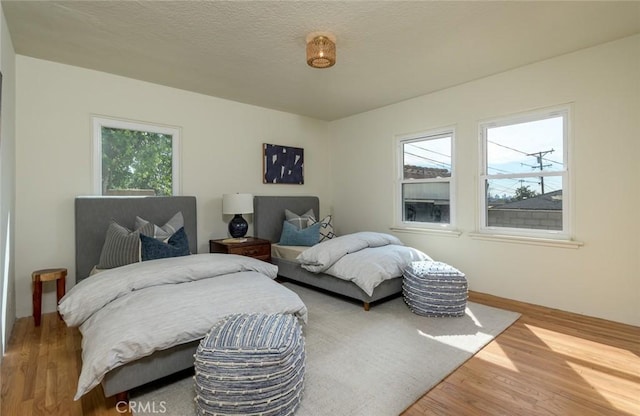 bedroom featuring a textured ceiling and wood finished floors