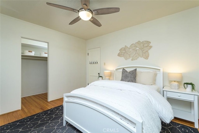 bedroom featuring a closet, wood finished floors, and a ceiling fan