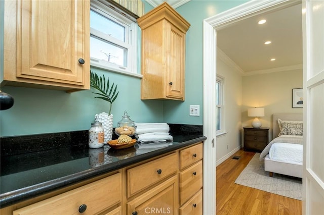 kitchen featuring ornamental molding, light wood-type flooring, and light brown cabinets