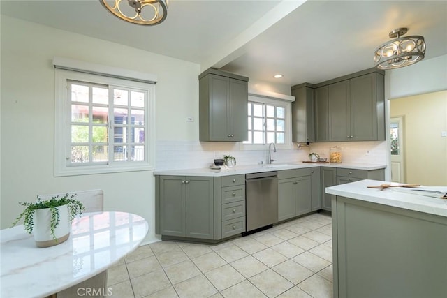 kitchen with tasteful backsplash, gray cabinets, a sink, and stainless steel dishwasher