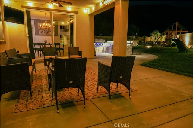 patio at twilight featuring playground community, outdoor dining space, a grill, and a ceiling fan