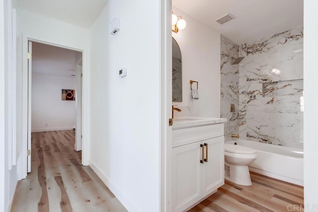 bathroom featuring bathtub / shower combination, visible vents, toilet, vanity, and wood finished floors