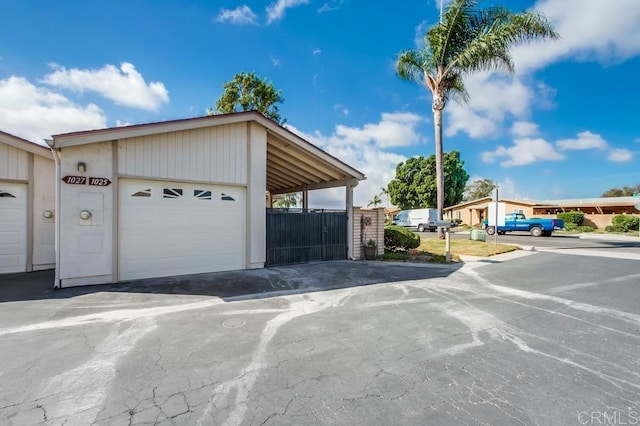 garage with fence and a carport