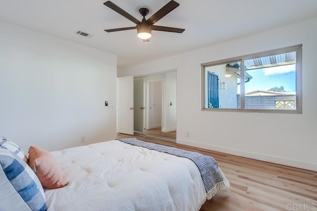 bedroom with a ceiling fan, visible vents, baseboards, a closet, and light wood-type flooring