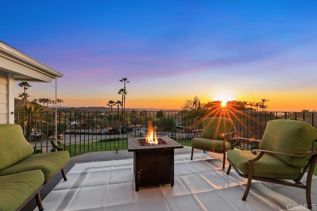 patio terrace at dusk featuring an outdoor fire pit