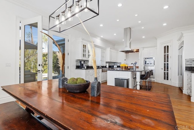 dining space featuring ornamental molding, recessed lighting, and dark wood-type flooring