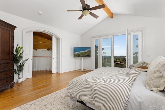 bedroom with arched walkways, light wood finished floors, lofted ceiling with beams, ceiling fan, and access to outside