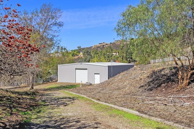 view of outbuilding with an outbuilding, fence, and a mountain view