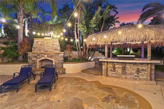 view of patio featuring a gazebo and an outdoor stone fireplace