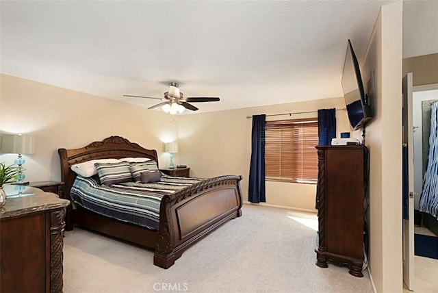 bedroom featuring a ceiling fan, light carpet, and baseboards