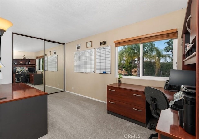 home office featuring light carpet and baseboards