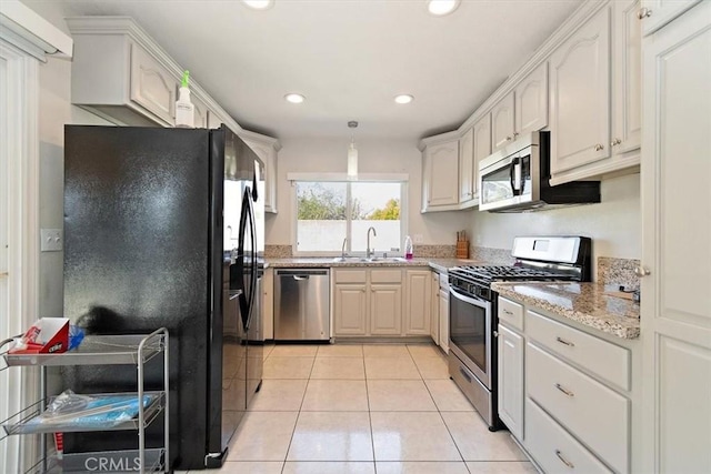 kitchen featuring light tile patterned floors, light stone counters, stainless steel appliances, a sink, and recessed lighting